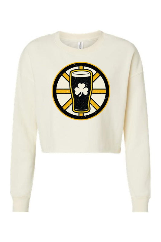 Cream-colored women's crop sweatshirt featuring a black, gold, and white beer glass graphic with a shamrock emblem.