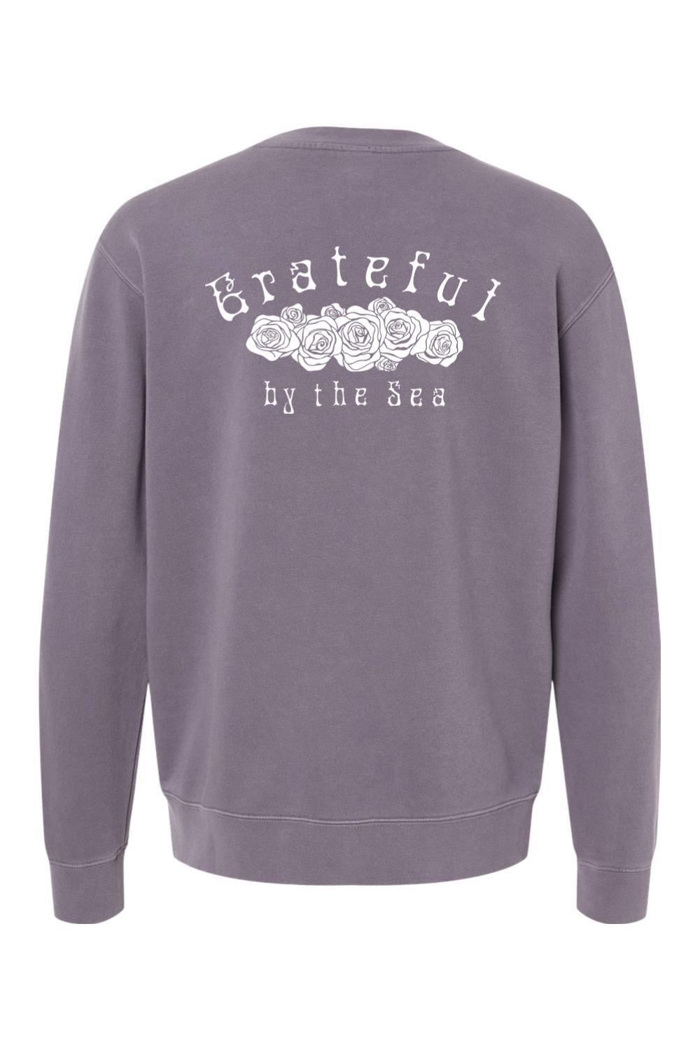 Purple pigment-dyed crewneck sweatshirt featuring a white Grateful by the Sea rose graphic on the back.