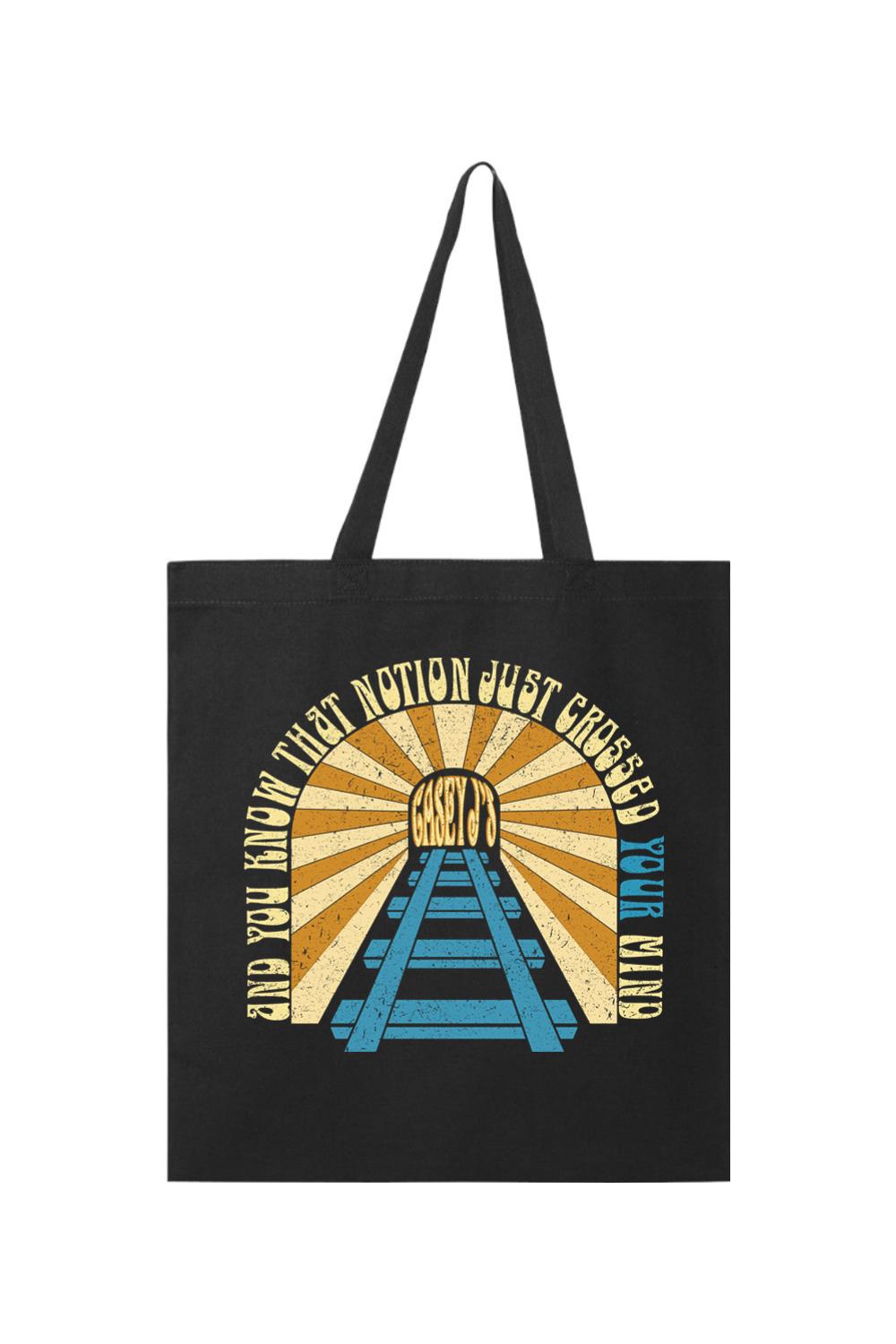 Black canvas tote bag featuring a vintage sunset graphic with railroad tracks and Casey J's text.
