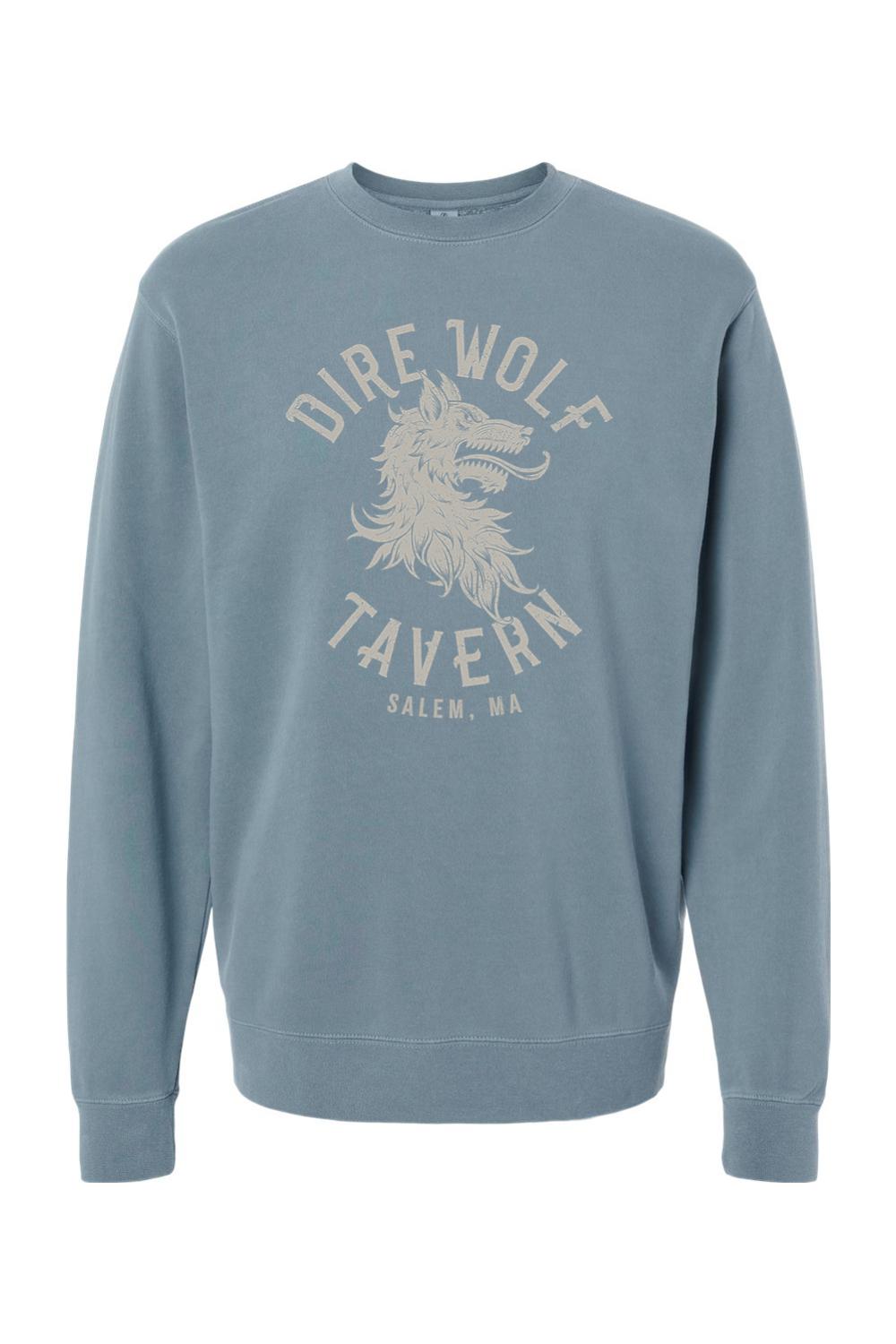 Blue pigment-dyed crewneck sweatshirt featuring a vintage Dire Wolf Tavern logo graphic in cream on the chest.