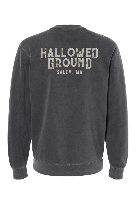 Charcoal pigment-dyed crewneck sweatshirt featuring Hallowed Ground Salem, MA text graphic on the back.