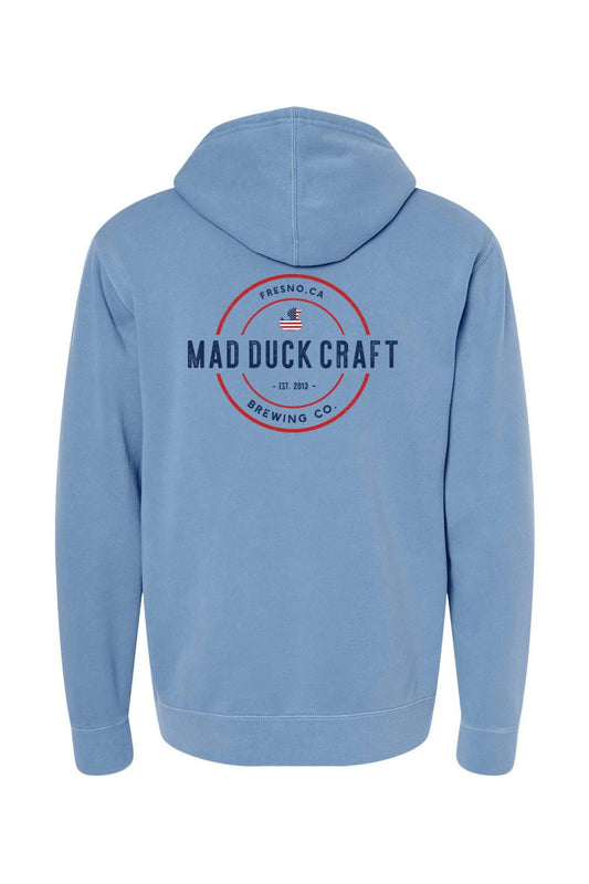 Blue pigment-dyed hoodie featuring a red and blue Mad Duck Craft Brewing Co. logo on the back.