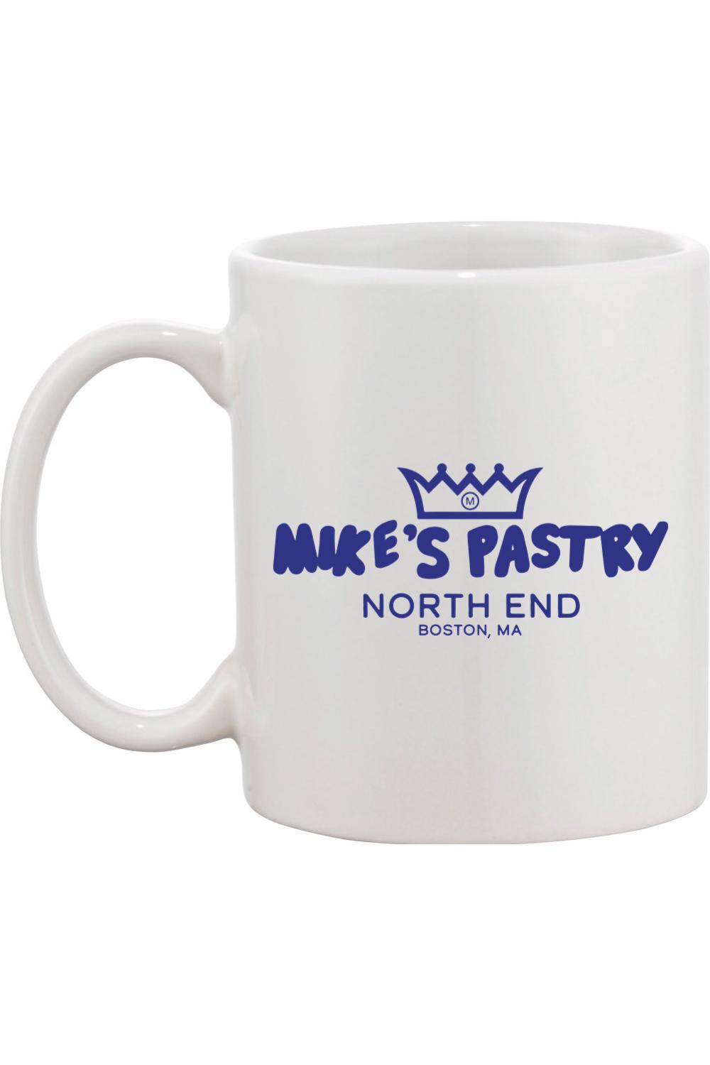 White ceramic mug featuring the blue Mike's Pastry North End logo with a crown icon.
