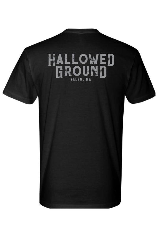 Back of a black cotton t-shirt featuring distressed white Hallowed Ground Salem, MA text across the upper back.