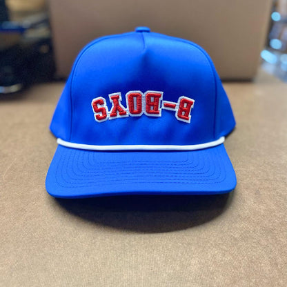 Bright blue structured cap featuring reversed red B-BOYS embroidery and a decorative white rope trim on the brim.