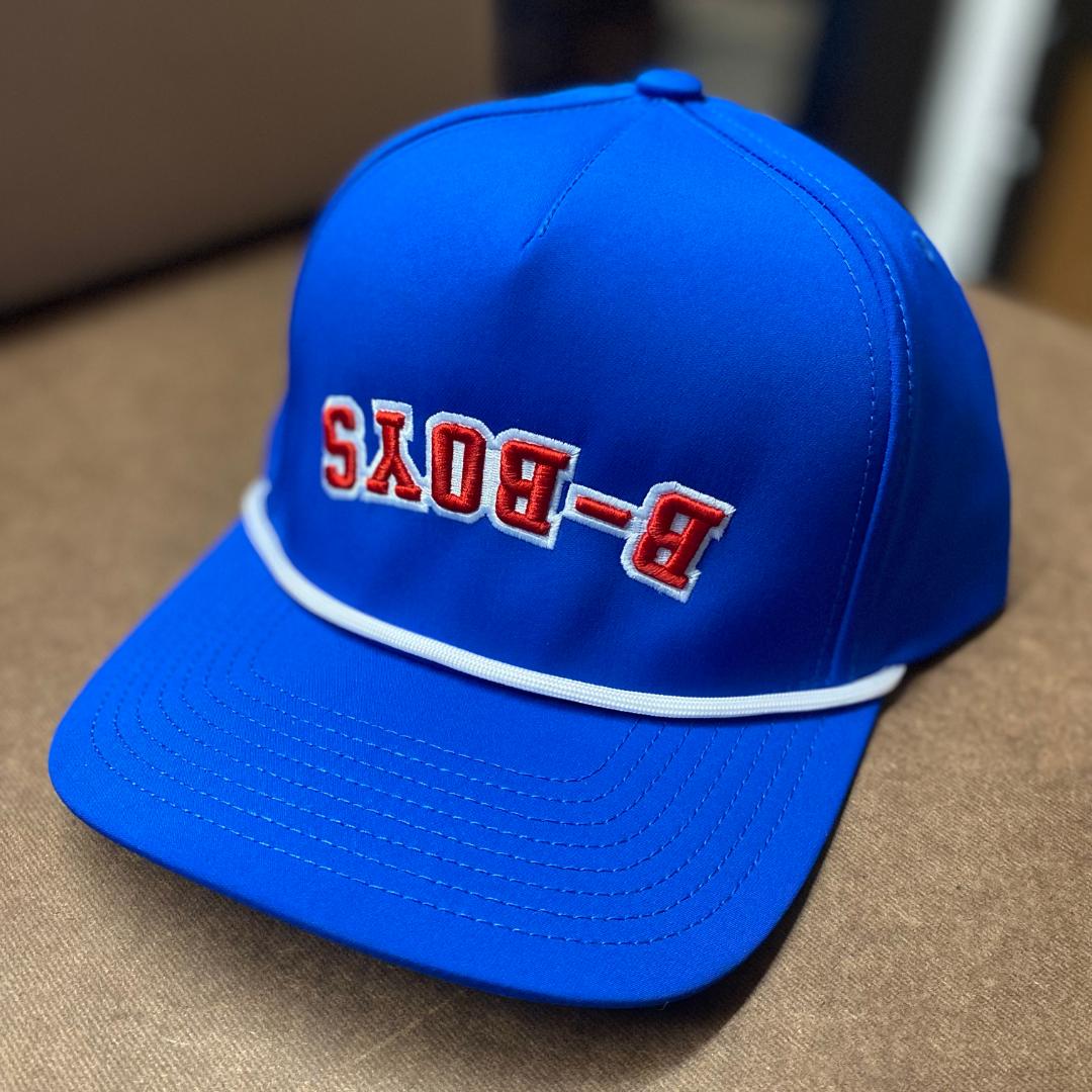 Royal blue baseball cap featuring a white rope trim and red embroidered B-BOYS text in a reversed design.