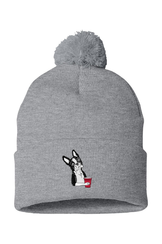 Grey knit beanie with a pom-pom, featuring an embroidered Boston terrier holding a red party cup.