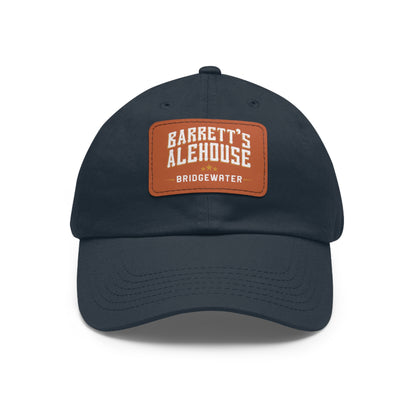 Navy blue unstructured dad cap with a brown faux leather patch featuring Barrett's Alehouse Bridgewater logo.