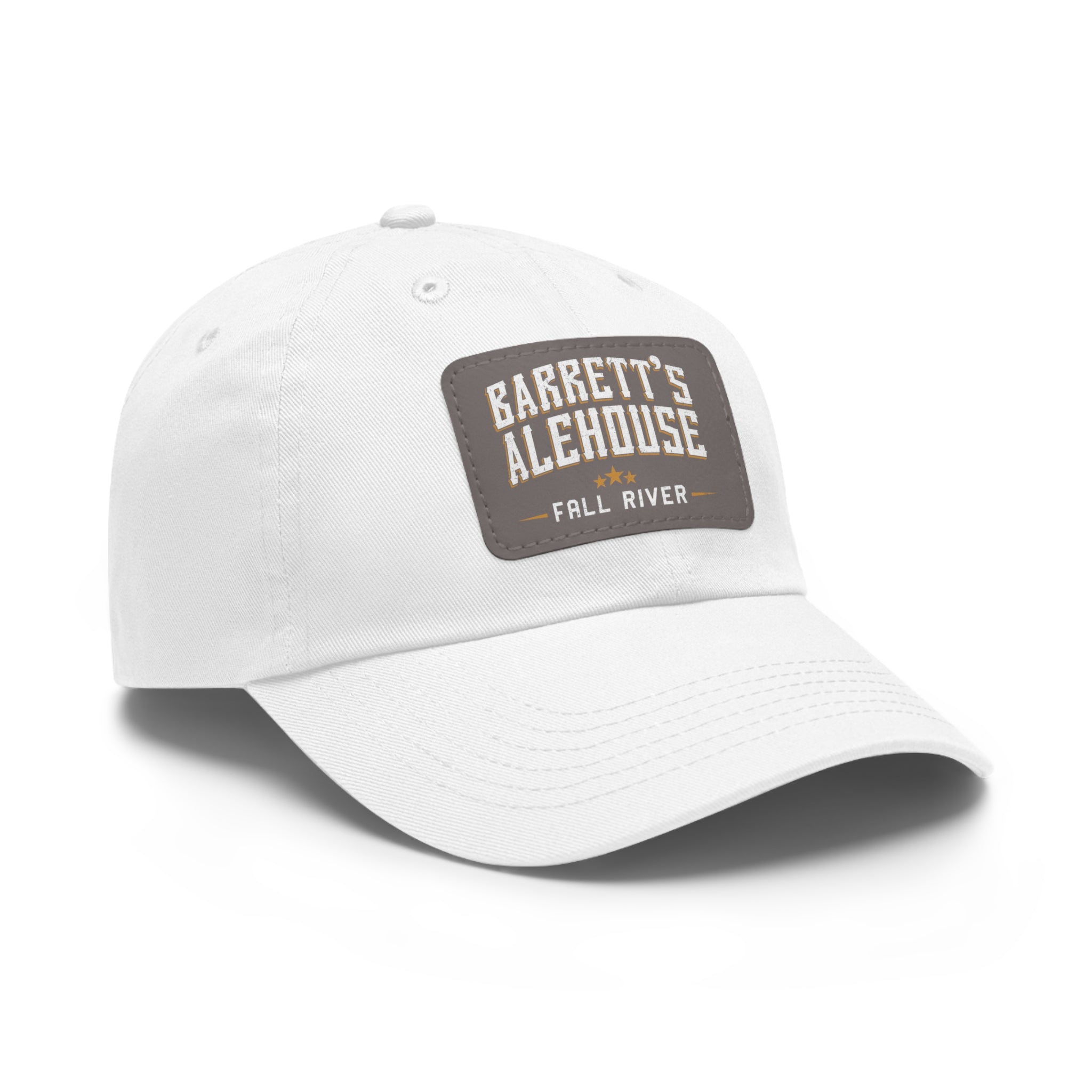 White unstructured dad hat with a brown faux leather patch featuring the Barrett's Alehouse Fall River logo.