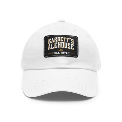 White unstructured dad hat with a black faux leather patch featuring the Barrett's Alehouse Fall River logo.