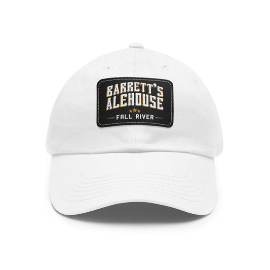 White unstructured dad hat with a black faux leather patch featuring the Barrett's Alehouse Fall River logo.