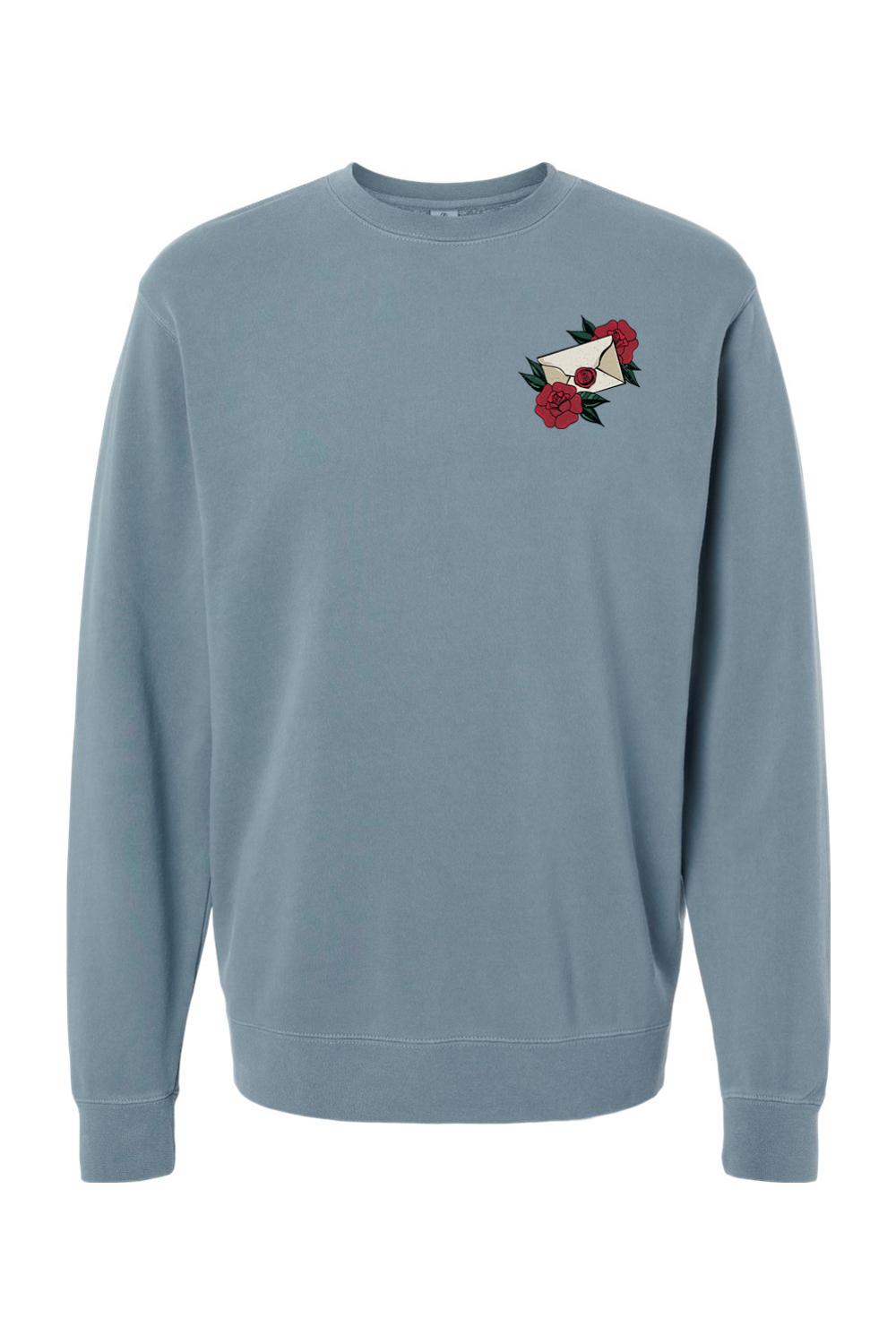 Blue pigment-dyed crewneck sweatshirt featuring a small embroidered rose and envelope design on the chest.