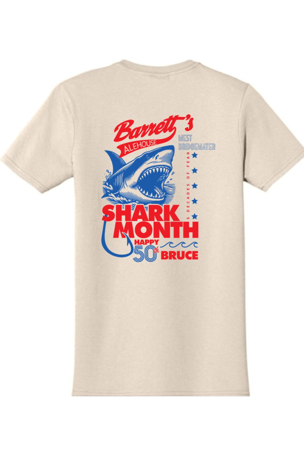 Beige 100% cotton t-shirt featuring a blue and red Shark Month 2025 graphic with a shark illustration on the back.