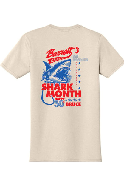 Beige 100% cotton t-shirt featuring a blue and red Shark Month 2025 graphic with a shark illustration on the back.