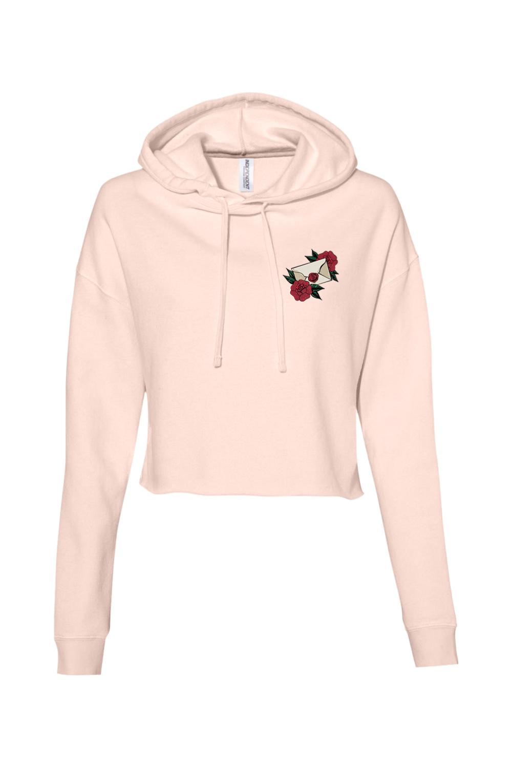 Light pink cropped hoodie featuring a small embroidered envelope and red rose design on the chest.