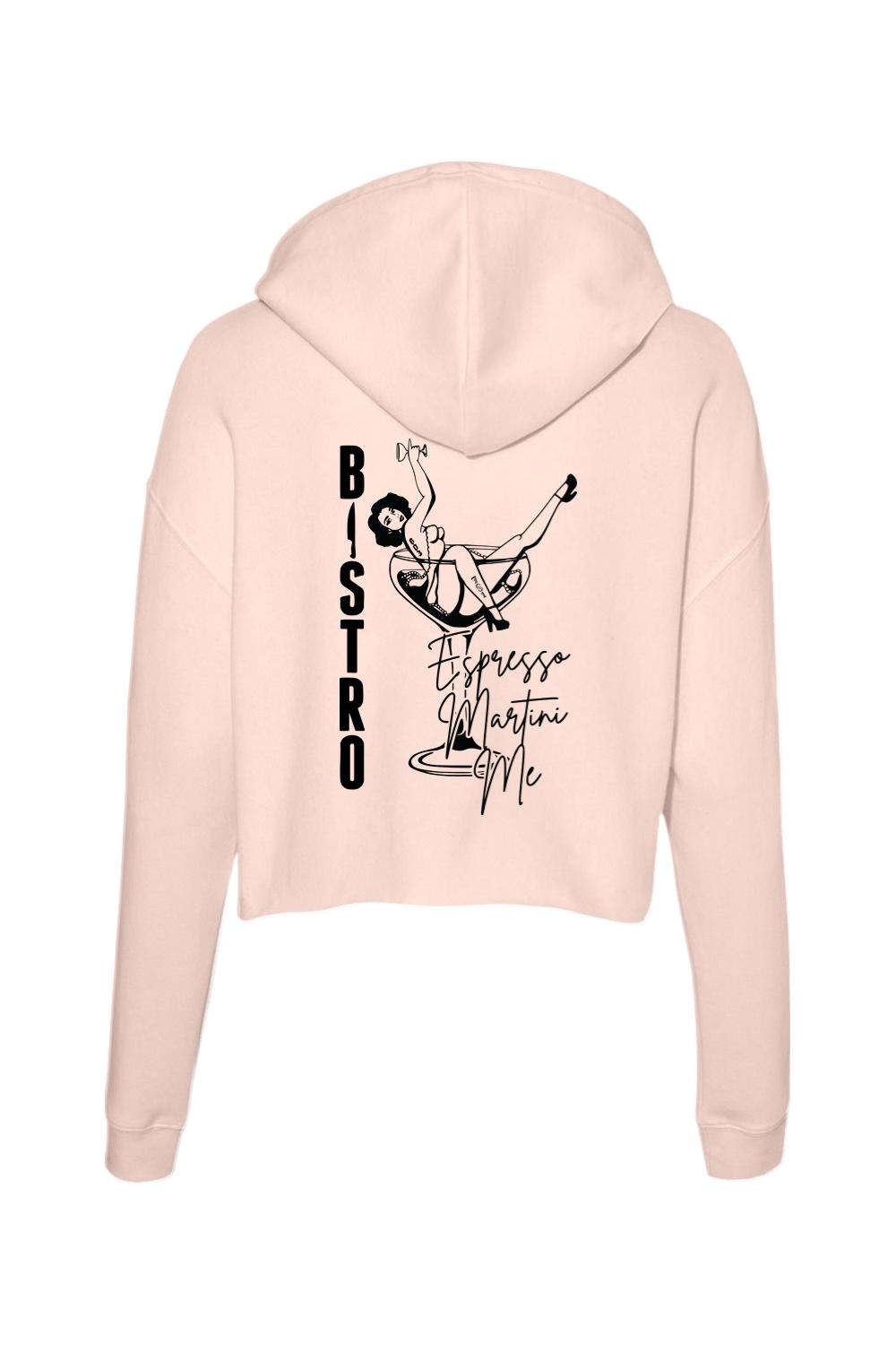 Light pink cropped hoodie featuring a black graphic of a woman in a martini glass with Bistro Espresso Martini text.