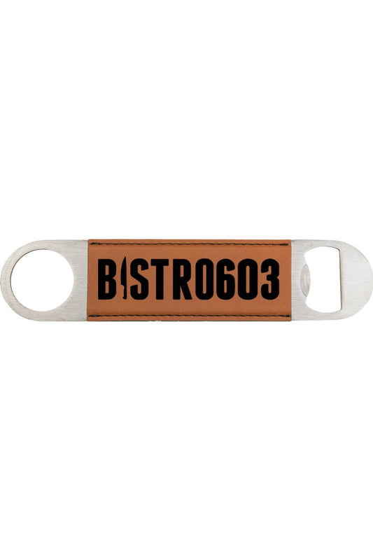 Tan leatherette bottle opener with a stainless steel frame and engraved Bistro603 logo in black.