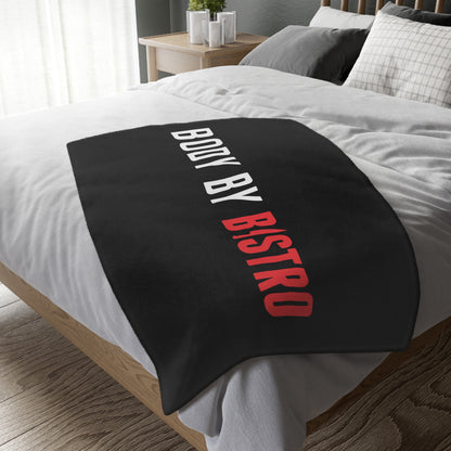 Soft black velveteen minky blanket with Body by Bistro text in white and red, draped over a bed.
