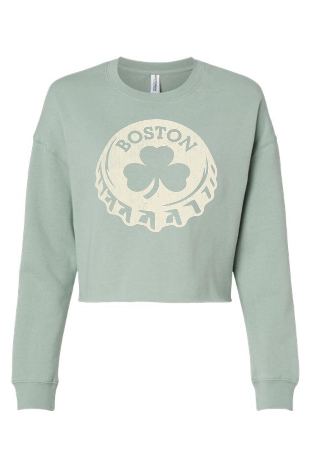 Sage green women's crop sweatshirt featuring a cream-colored Boston shamrock bottle cap graphic print.