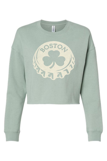 Sage green women's crop sweatshirt featuring a cream-colored Boston shamrock bottle cap graphic print.