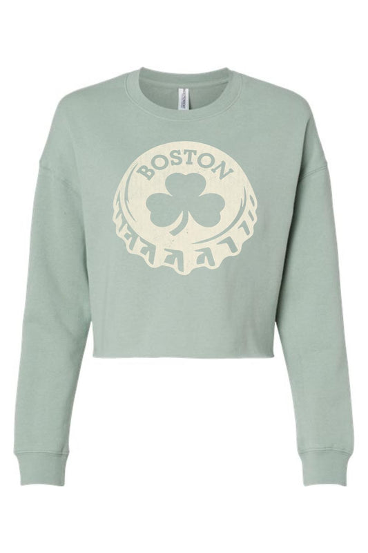 Sage green women's crop sweatshirt featuring a cream-colored Boston shamrock bottle cap graphic print.