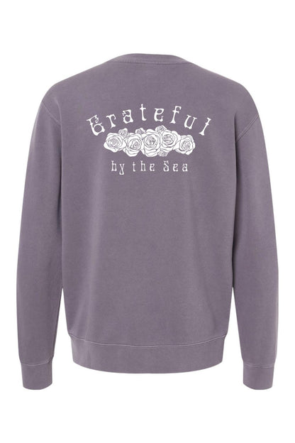 Purple pigment-dyed crewneck sweatshirt featuring a white Grateful by the Sea rose graphic on the back.