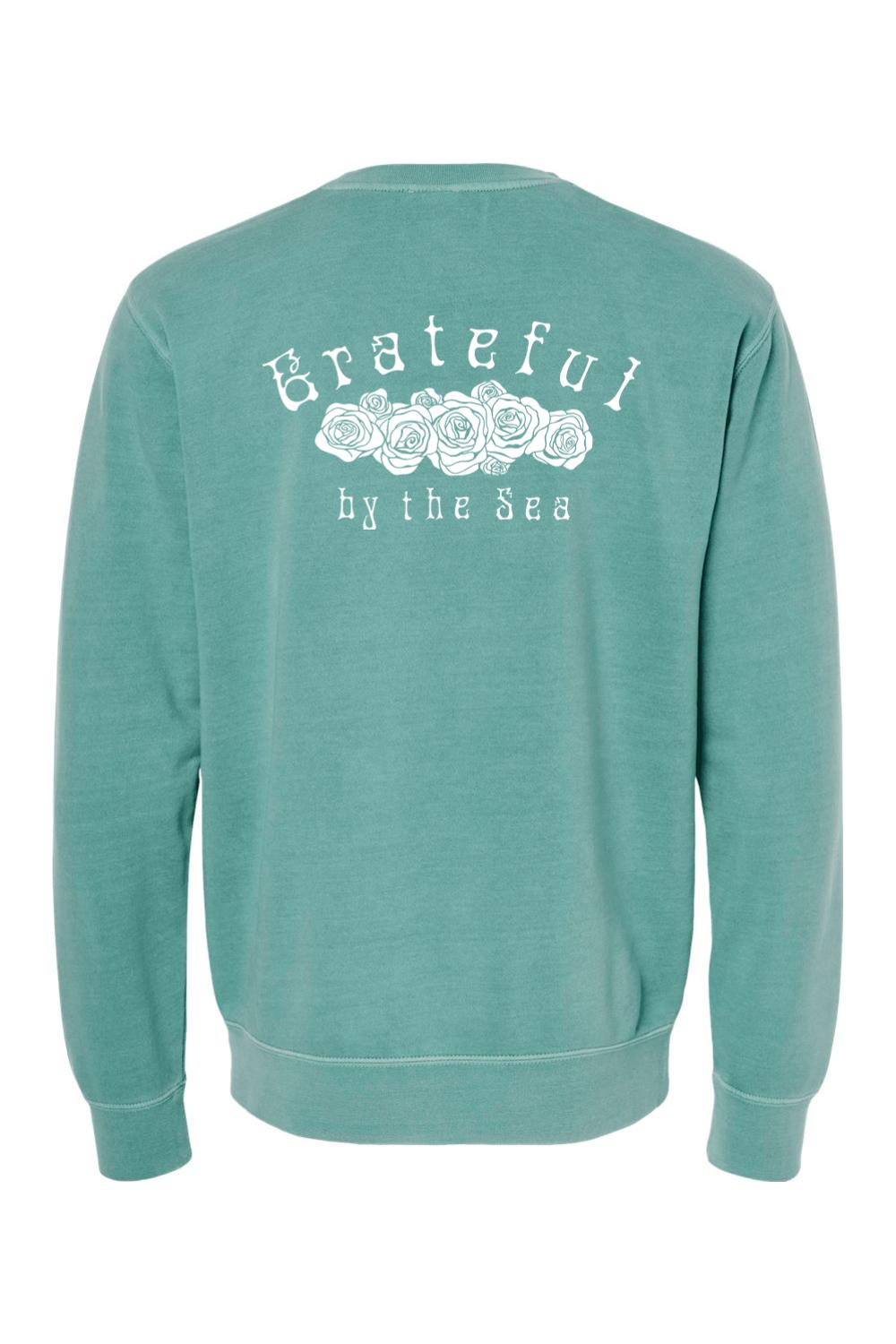Seafoam green pigment-dyed crewneck sweatshirt with white Grateful By The Sea rose graphic on the back.