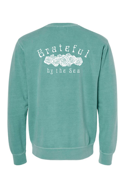 Seafoam green pigment-dyed crewneck sweatshirt with white Grateful By The Sea rose graphic on the back.
