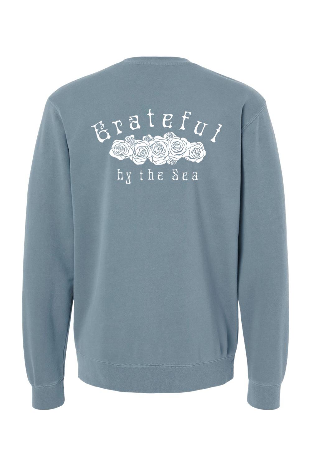 Blue pigment-dyed crewneck sweatshirt featuring a white Grateful by the Sea rose graphic on the back.