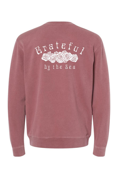 Dusty rose pigment-dyed crewneck sweatshirt featuring a white Grateful by the Sea rose graphic on the back.