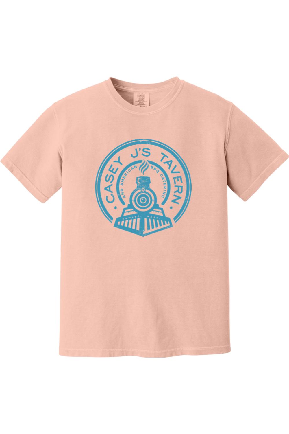 Soft peach Comfort Colors t-shirt featuring a blue Casey J's Tavern train logo graphic on the front.
