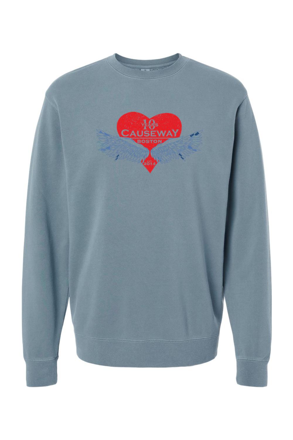 Blue pigment-dyed crewneck sweatshirt featuring a red heart graphic with wings and Causeway 10th anniversary text.