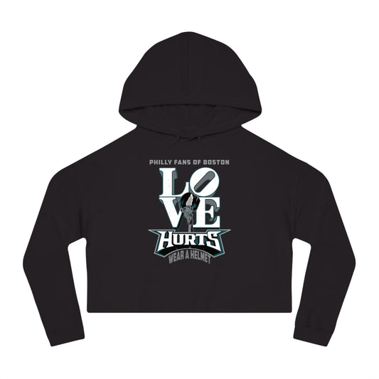 Black crop graphic hoodie featuring Love Hurts text and a football helmet design on soft cotton-blend fleece.