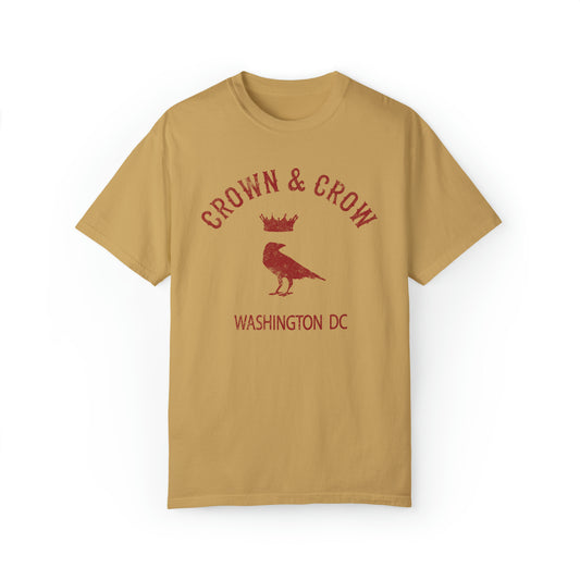 Relaxed fit, garment-dyed tan cotton t-shirt featuring a distressed red Crown & Crow logo with a bird graphic.