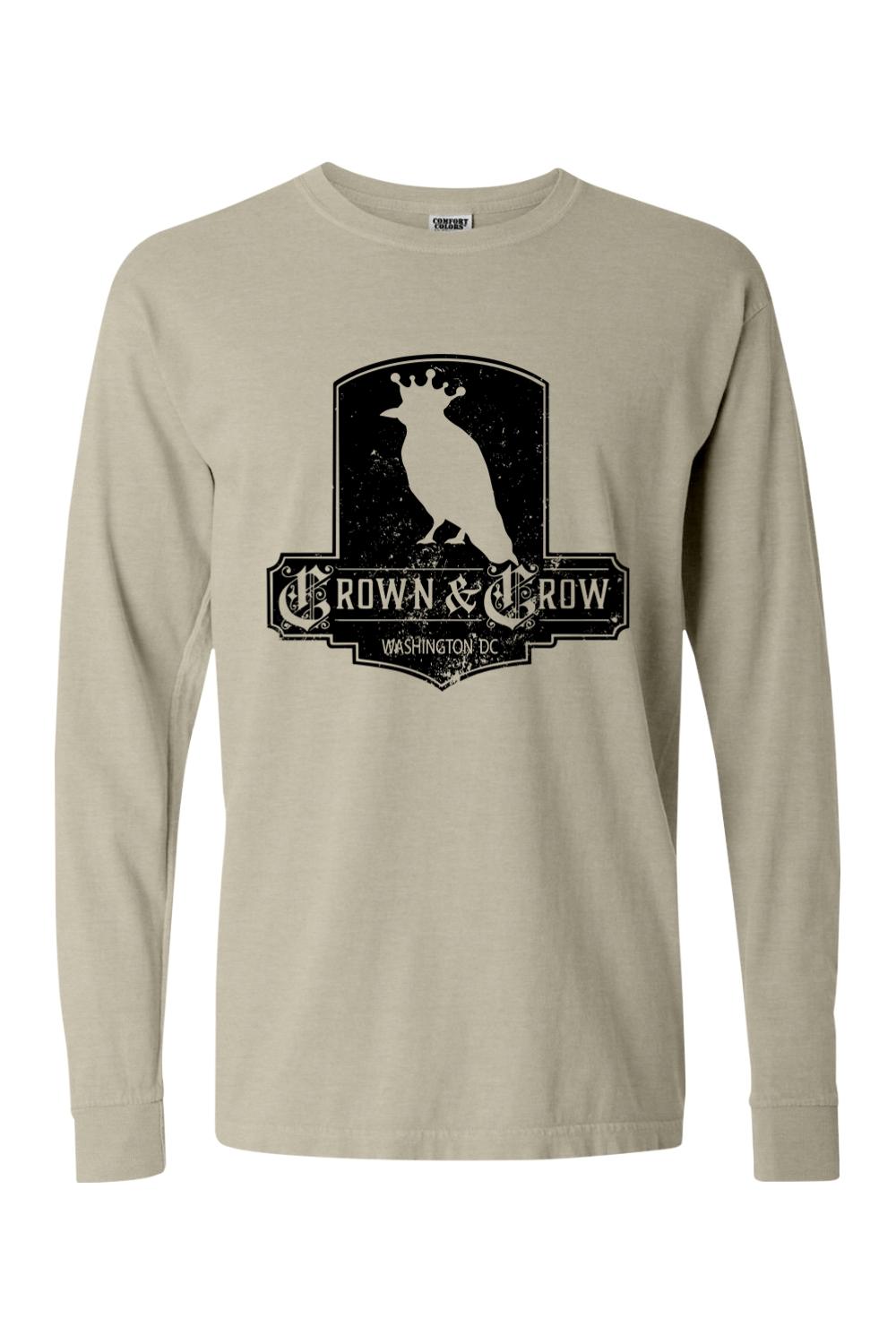 Tan garment-dyed long sleeve t-shirt featuring a black distressed Crown & Crow logo graphic on the chest.