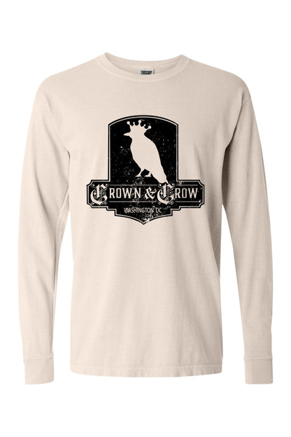 Beige garment-dyed long sleeve t-shirt featuring a black distressed Crown & Crow logo graphic on the chest.