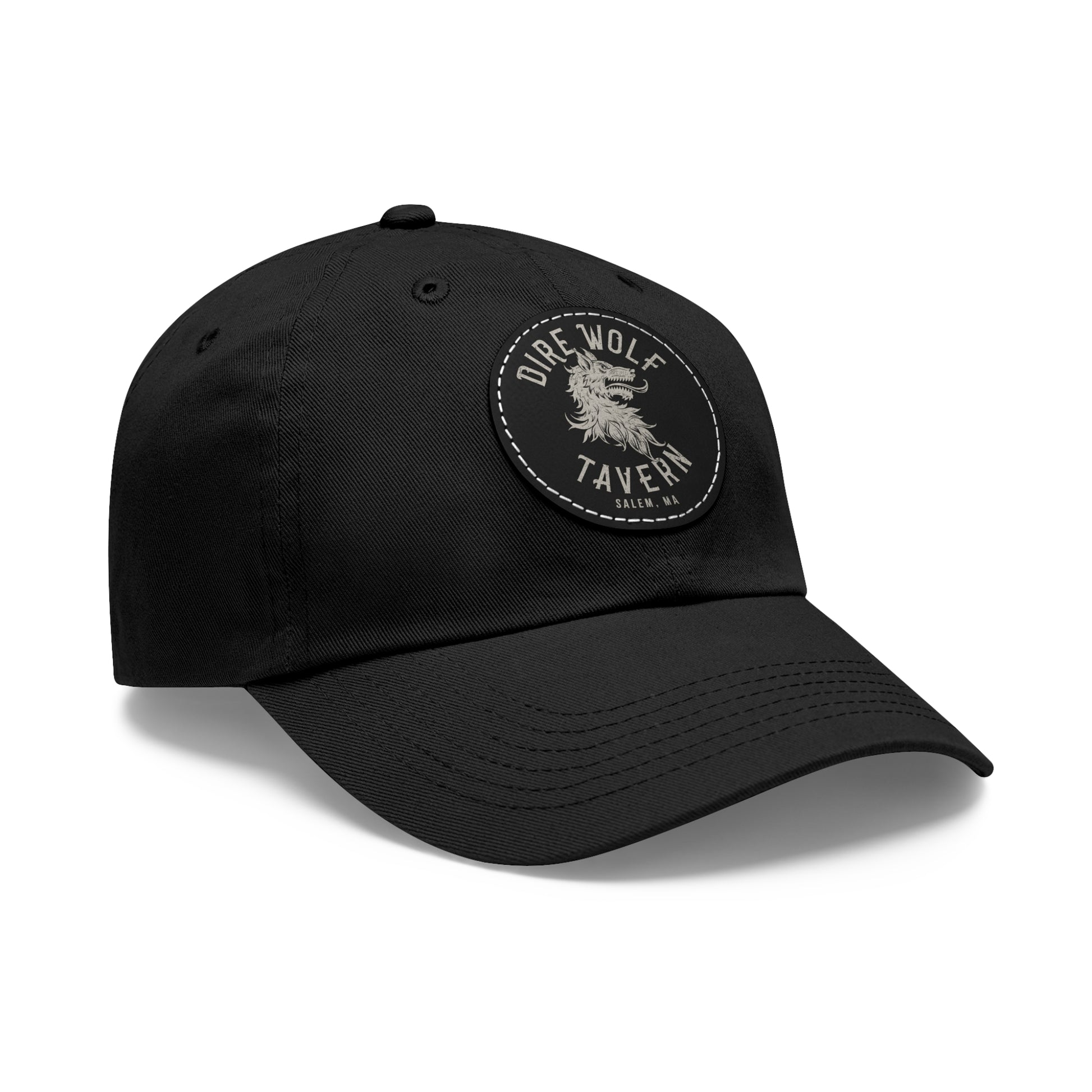 Black unstructured dad hat with a round PU leather patch featuring a Dire Wolf Tavern logo and pre-curved bill.