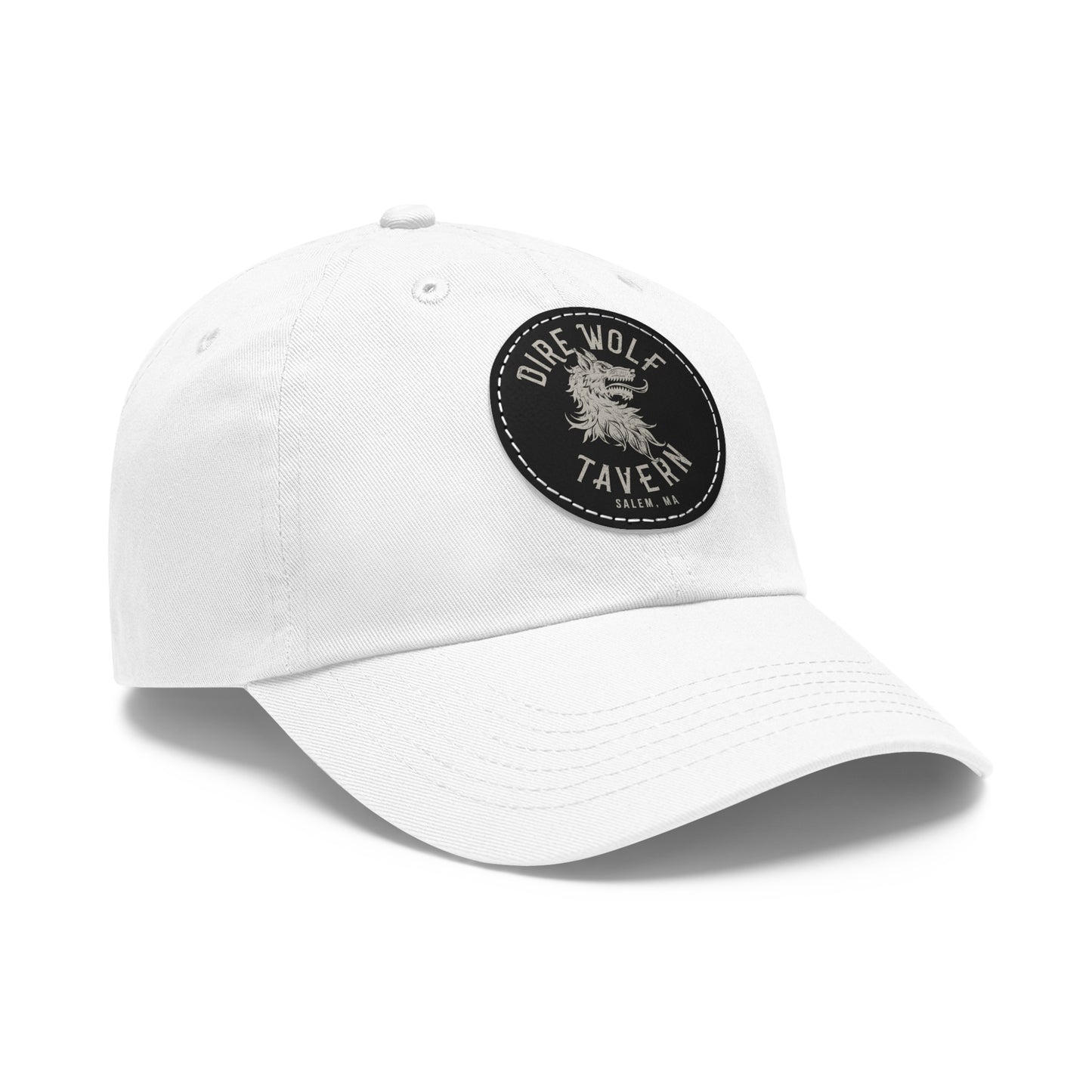 White unstructured dad hat with a round black PU leather patch featuring a Dire Wolf Tavern logo.
