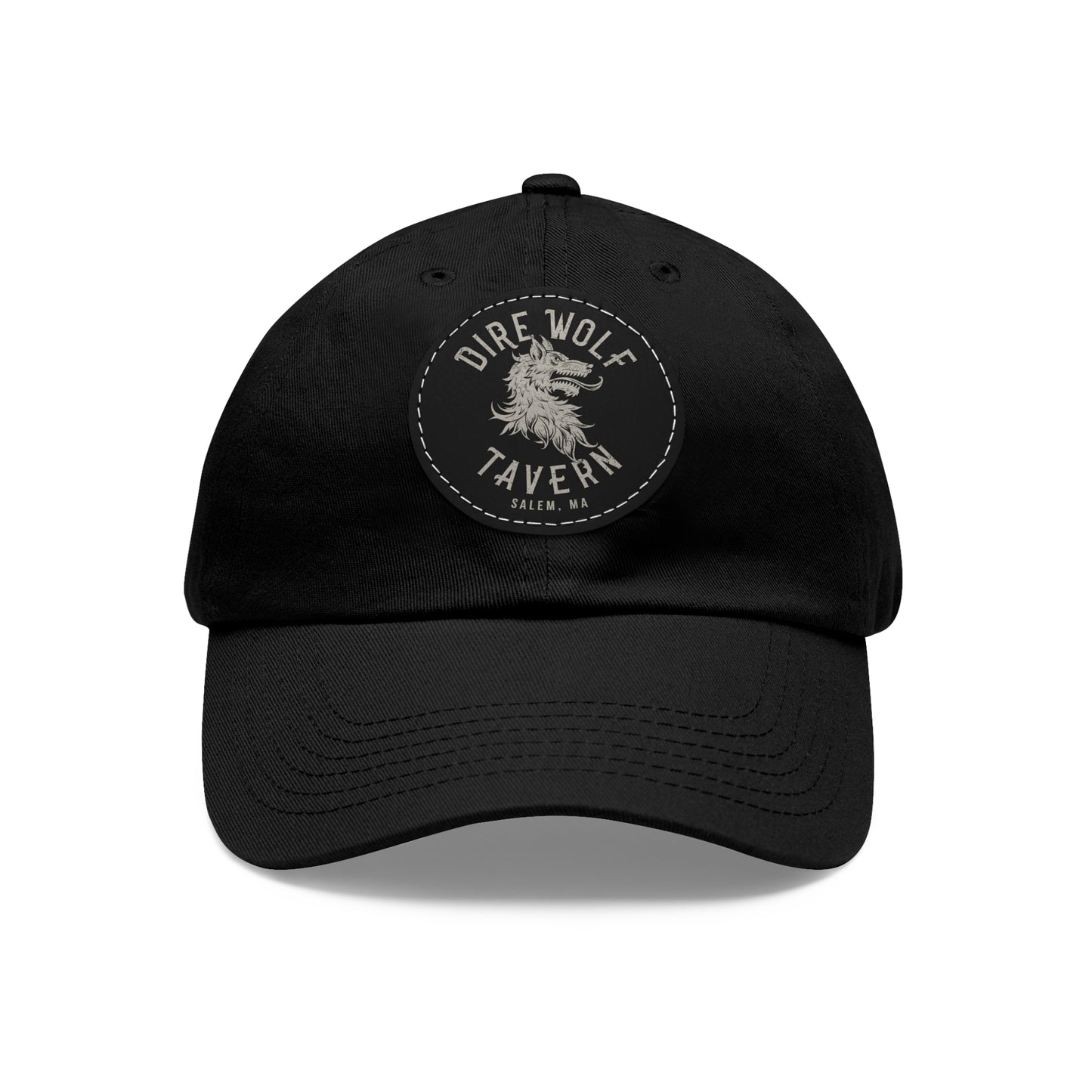 Black unstructured dad hat with a round PU leather patch featuring a Dire Wolf Tavern logo.