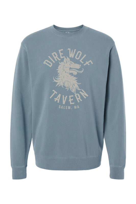Blue pigment-dyed crewneck sweatshirt featuring a vintage Dire Wolf Tavern logo graphic in cream on the chest.