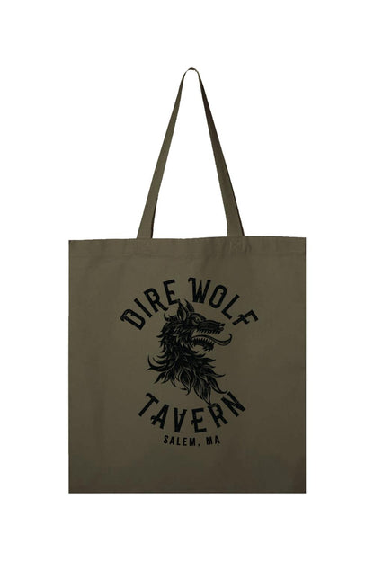 Olive green canvas tote bag featuring a black Dire Wolf Tavern Salem, MA graphic print and long shoulder straps.