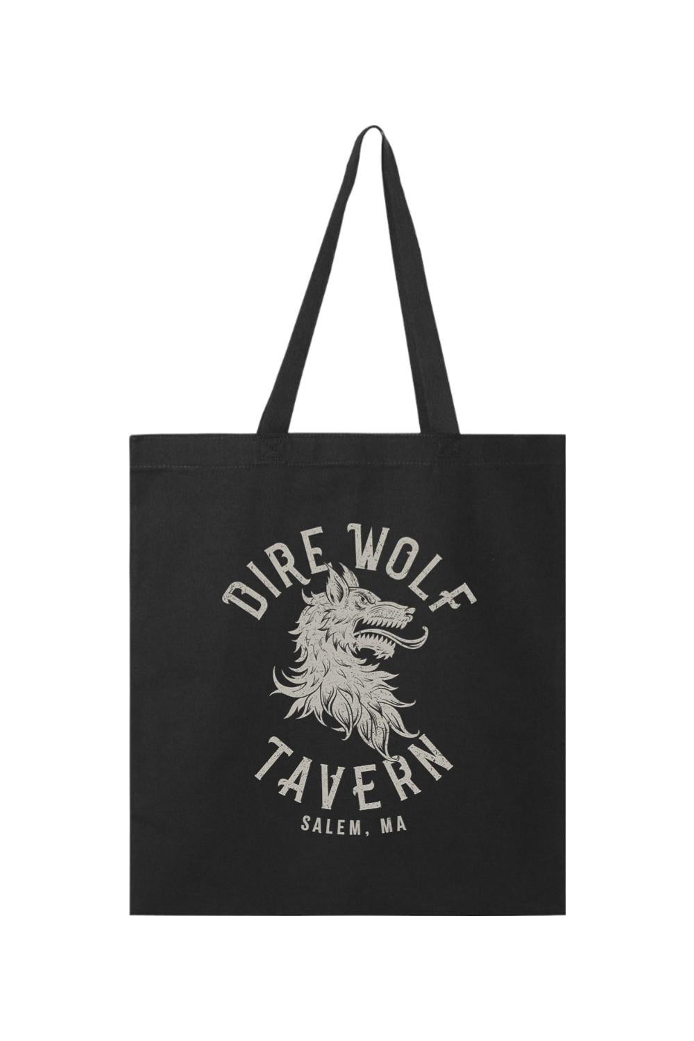Black canvas tote bag featuring a distressed white Dire Wolf Tavern Salem, MA graphic print and sturdy handles.