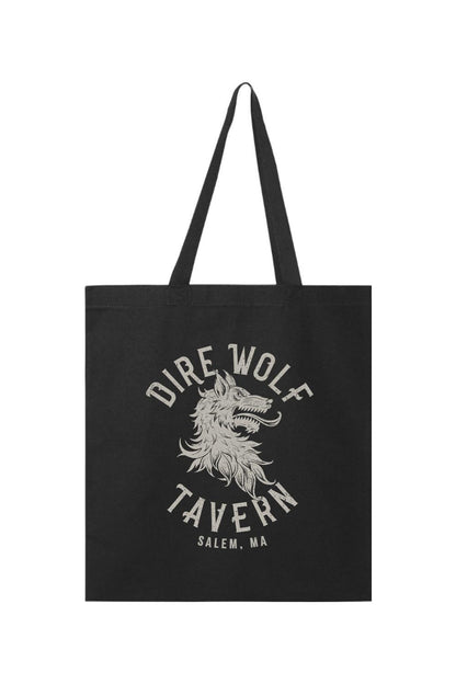 Black canvas tote bag featuring a distressed white Dire Wolf Tavern Salem, MA graphic print and sturdy handles.