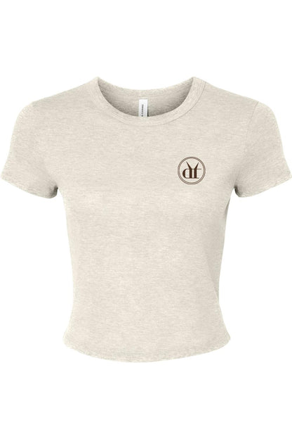 Beige micro rib baby tee with a small circular espresso martini logo on the chest and a fitted, cropped silhouette.