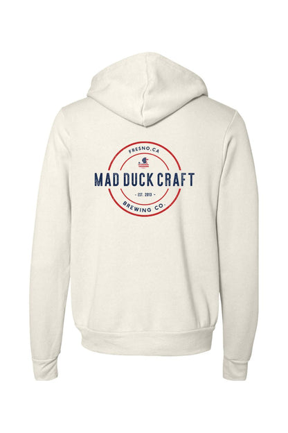 Cream-colored full-zip sponge fleece hoodie featuring a red, white, and blue Mad Duck Craft Brewing Co. logo on the back.