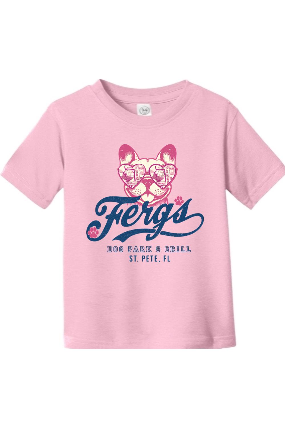 Light pink toddler cotton t-shirt featuring a French bulldog in heart-shaped sunglasses and Ferg's Dog Park & Grill logo.