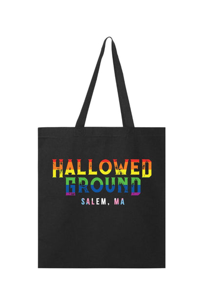 Black canvas tote bag featuring a rainbow-colored Hallowed Ground Salem, MA graphic print.