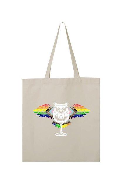 Beige canvas tote bag featuring a white owl graphic with vibrant rainbow-colored wings perched on a wine glass.