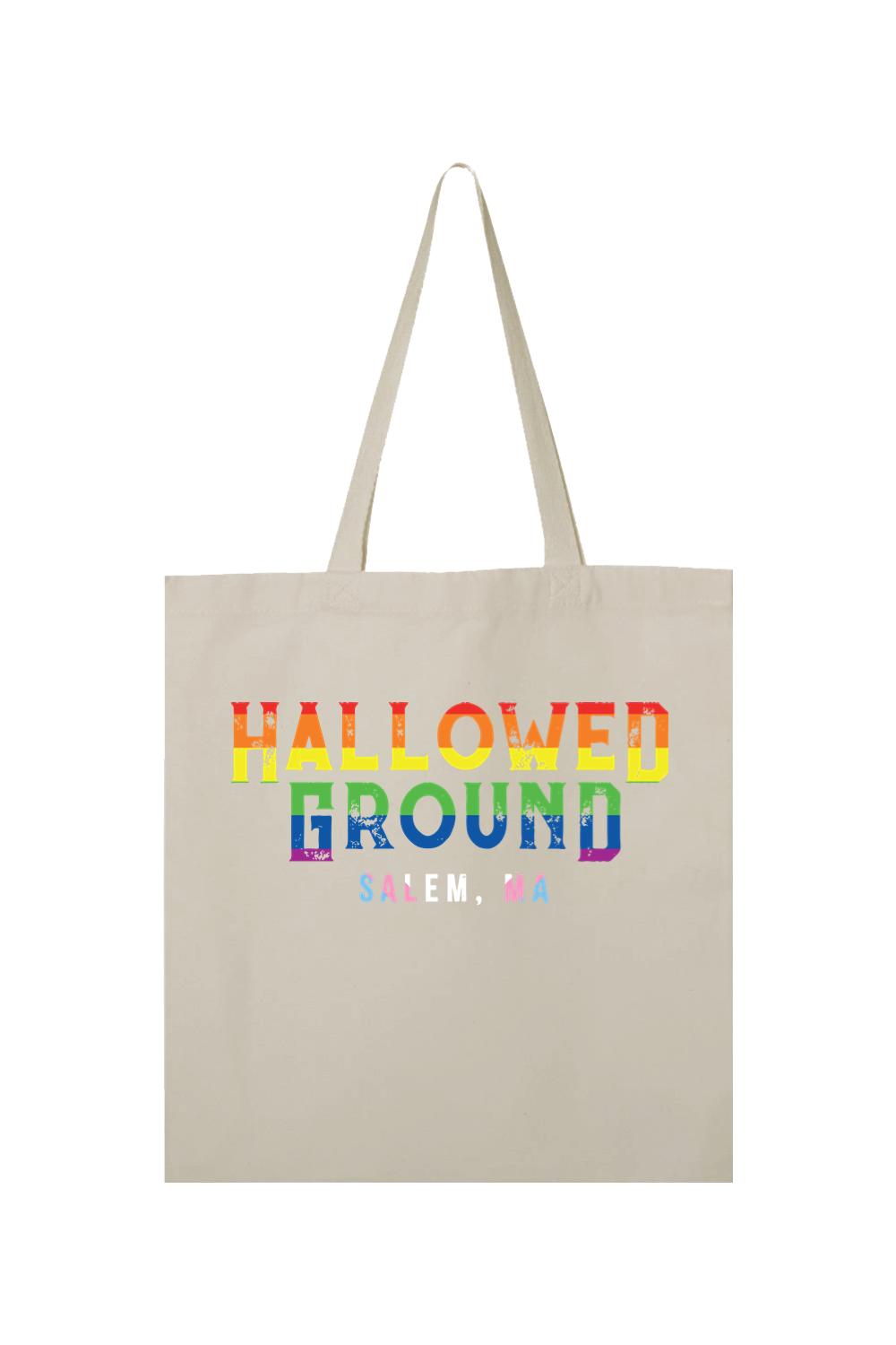 Beige canvas tote bag featuring Hallowed Ground Salem, MA text in a distressed rainbow gradient print.