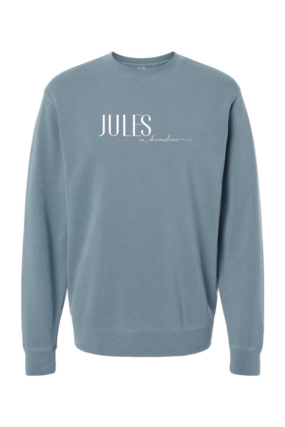 Blue pigment-dyed crewneck sweatshirt with white Jules on Devonshire logo text on the chest.